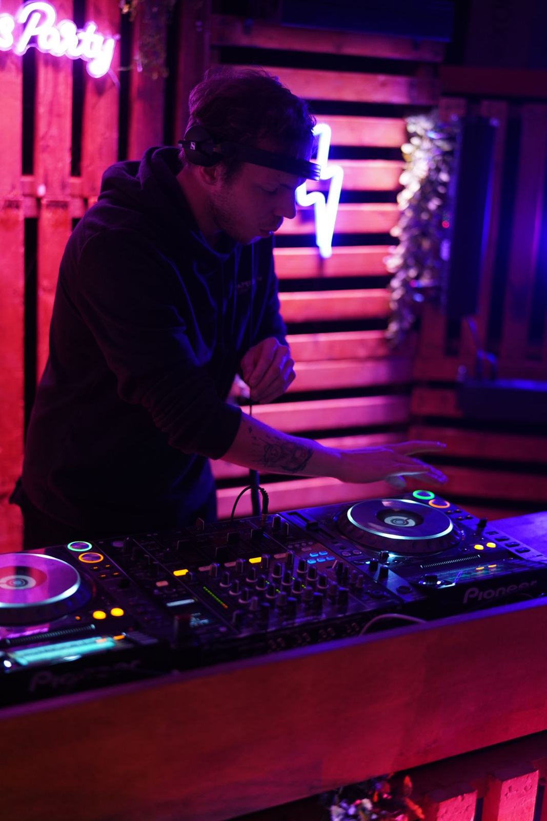 Milo Sava at the decks in pink and blue light